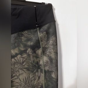 Black and green workout leggings with zipper pocket on waistband.